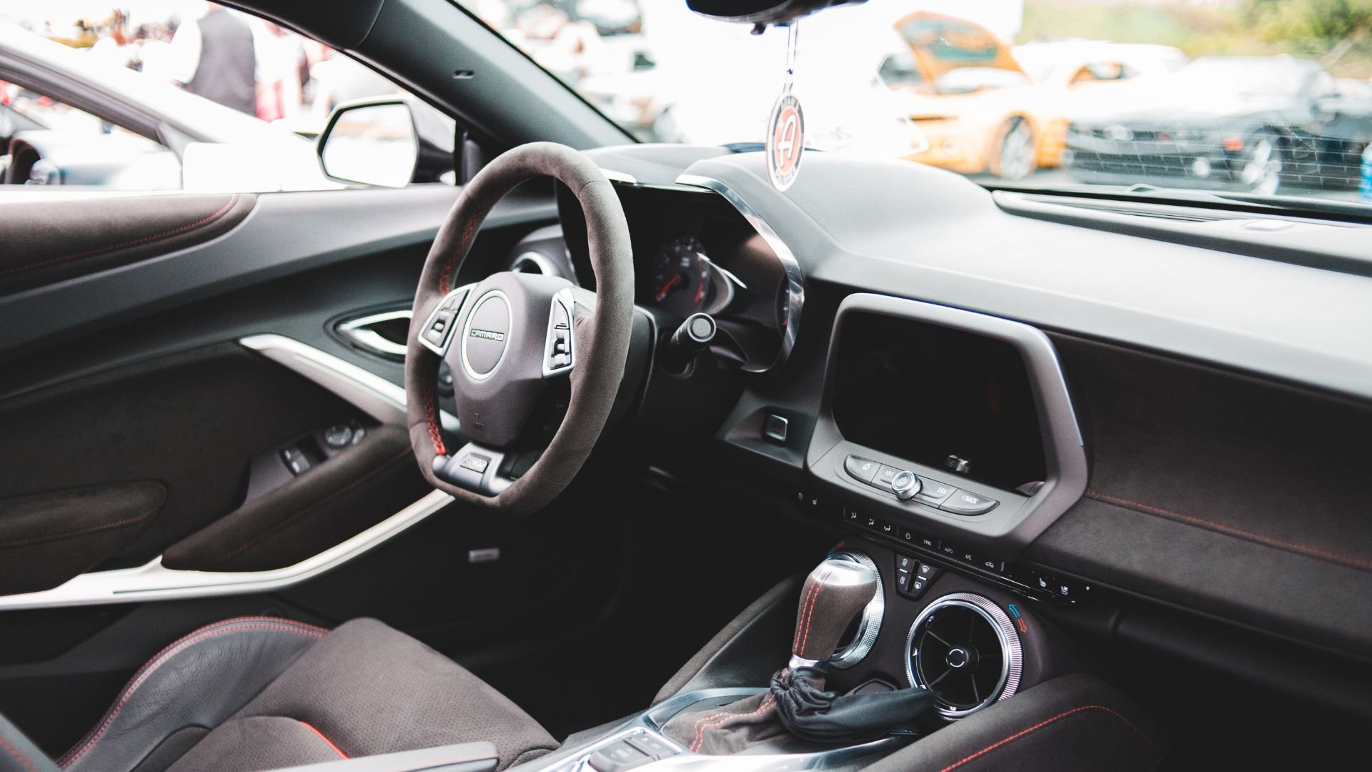 Modern car interior with steering wheel and dashboard in black