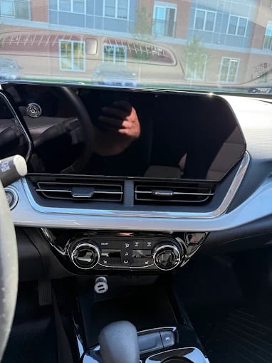 Modern car dashboard with climate controls and reflective window