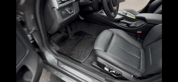 Black leather car interior with dashboard, steering wheel, and seat
