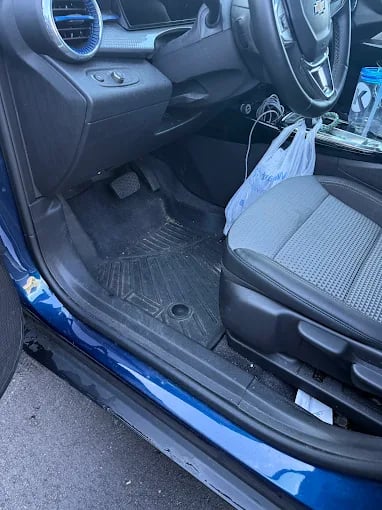 Dirty car interior floor with plastic bag on passenger seat