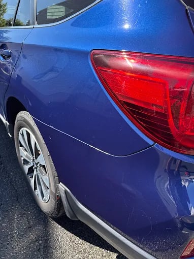Blue car with red taillight, close-up of rear quarter panel